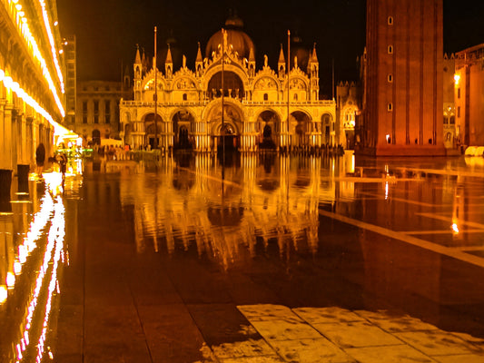 A Flooded St. Marks at Night - Fine Art Print captures St. Mark's Basilica and square in Venice, beautifully illuminated and reflected in floodwater, creating a stunning nighttime scene.
