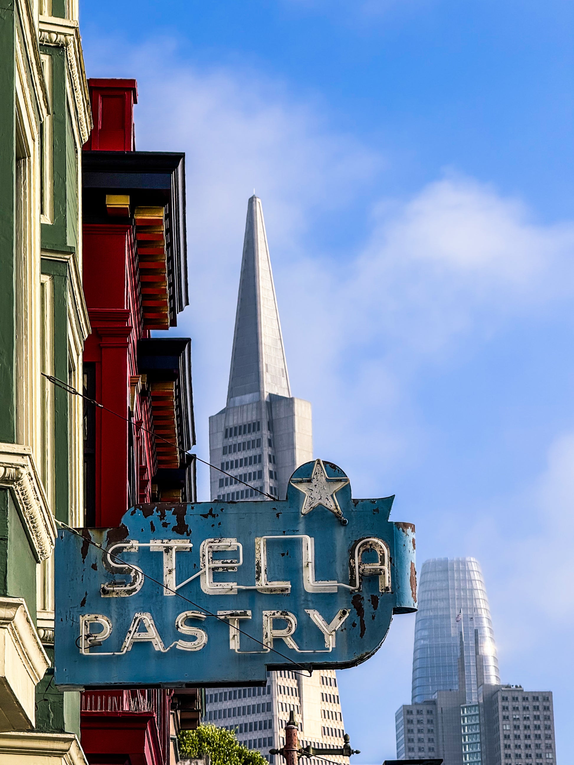 The Retro Stella Pastry Sign - Fine Art Print by Leslie Brashear Photography captures a classic North Beach San Francisco sign with the Transamerica Pyramid and Salesforce Tower in the background.