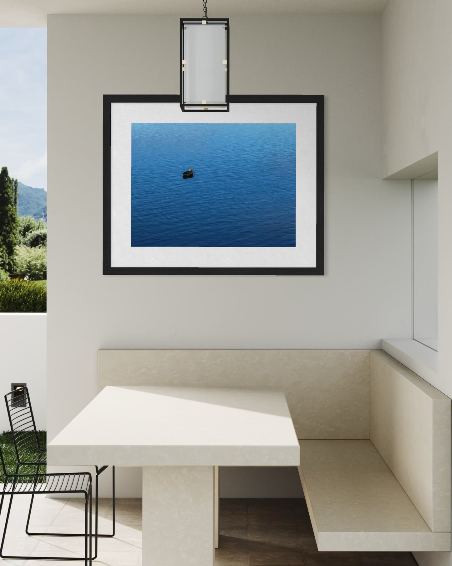 A minimalist dining nook with a built-in beige bench, table, black chair, and Serene Boat on Tranquil Waters fine art print by Leslie Brashear Photography—a calming lakeside scene—displayed on the wall.