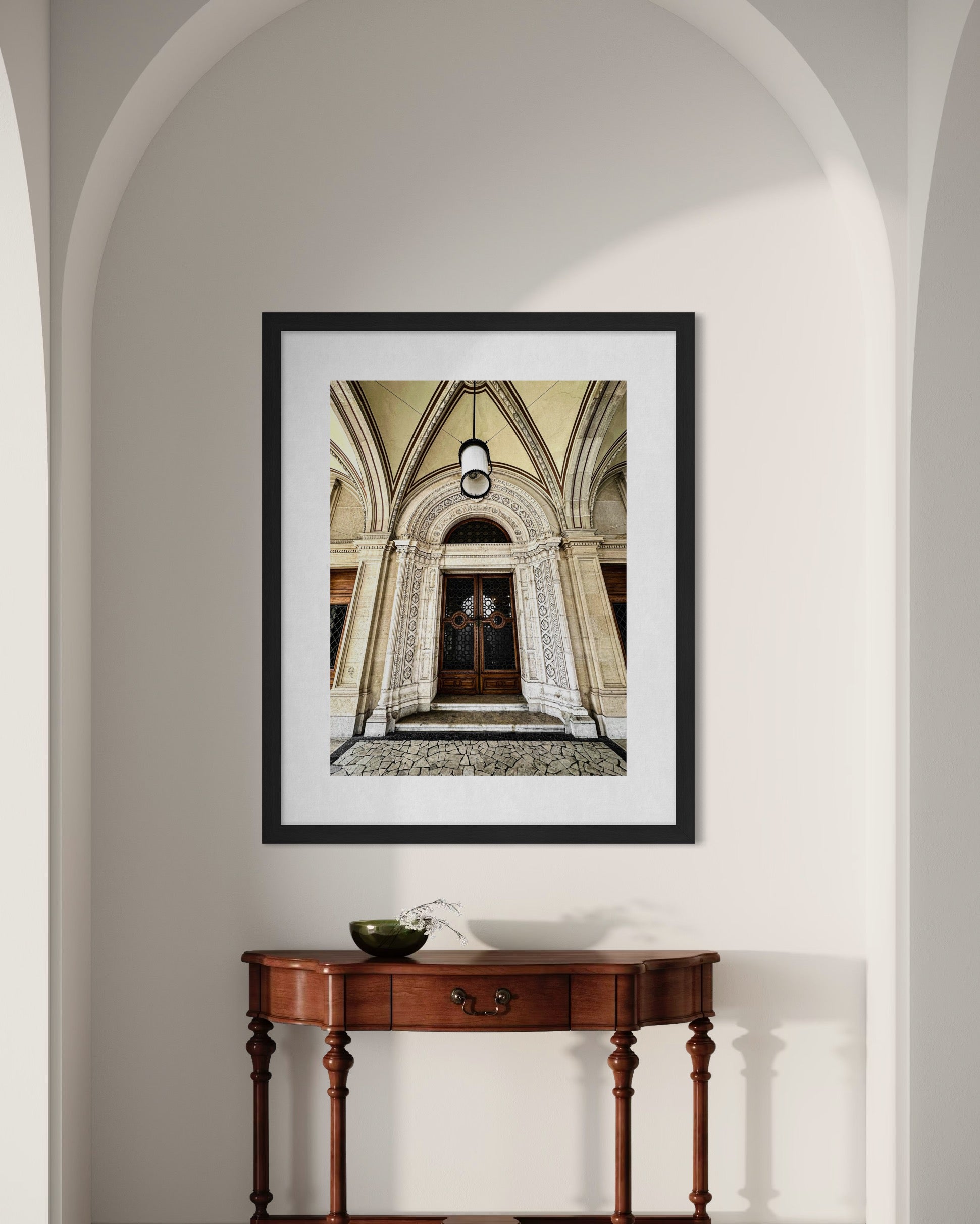 Doorway to the Opera - Fine Art Print by Leslie Brashear Photography is displayed in an elegant room, hanging above a wooden console table with a green bowl and surrounded by graceful arched architectural details.