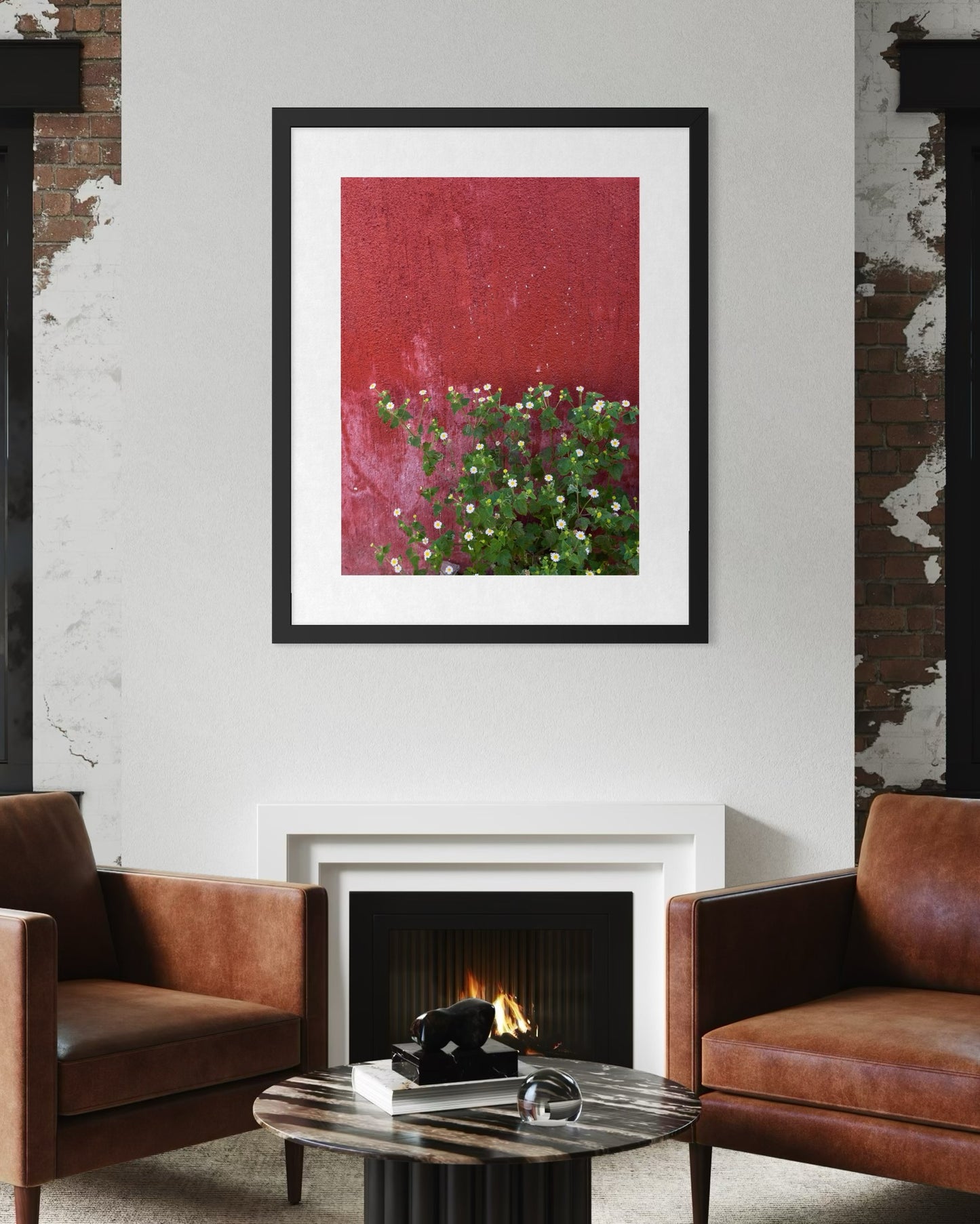 A modern living room with brown leather chairs, a white fireplace, and "Rustic Red Wall with Tiny Wildflowers" by Leslie Brashear Photography—a striking fine art print that brings bold color and botanical charm to the space.
