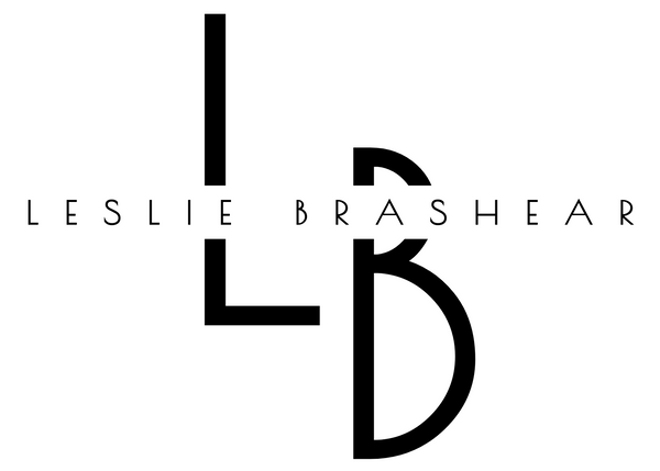 Black and white logo with 'Leslie Brashear' and stylized initials on a white background